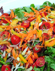 Cook prepares to pour dressing on salads