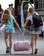 Two summer campers carry a bag together